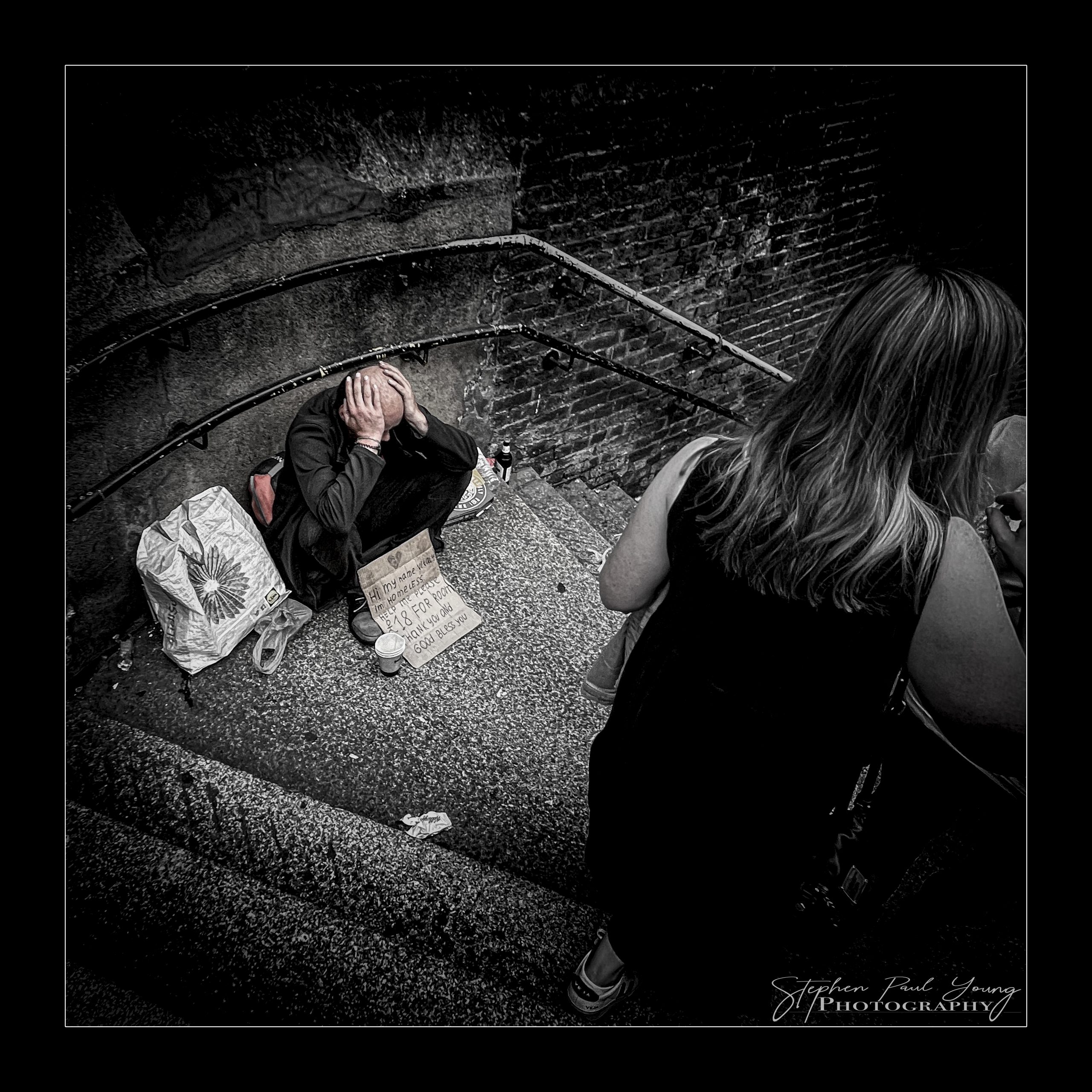 Indulge in 6 Savoury Photographs of Borough Market London: A Photographer's Gastronomic Delight 6 A homeless man sitting alone on the steps at Borough Market in London, captured in candid street photography.