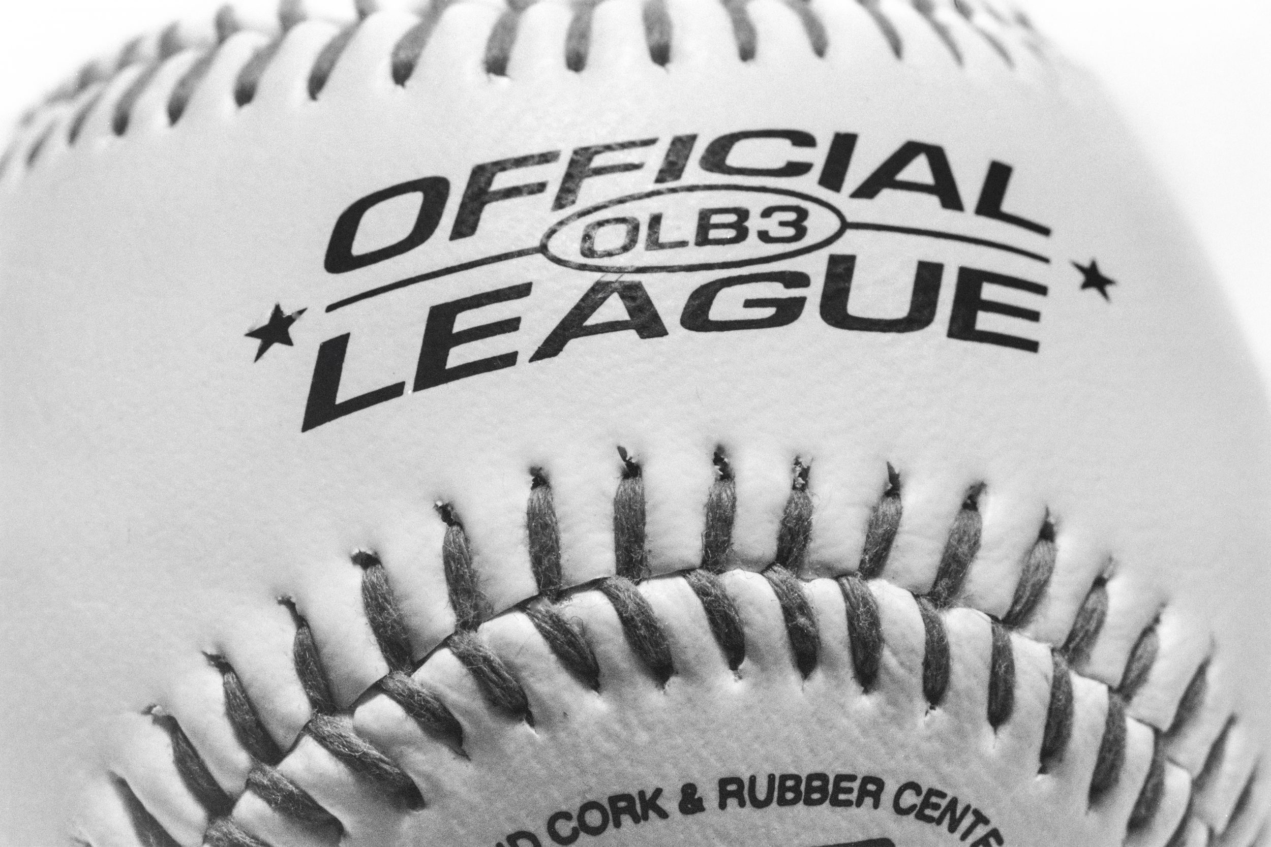 Baseball - The black and white sport picture captures the intricate texture and stitching of a baseball, evoking the spirit of the athletic game. The monochromatic palette enhances the raw intensity of the sport, while the detailed macro photography draws the viewer into the heart of the action. This image is a powerful testament to the timeless allure of baseball and the dedication of its players. Taken on 35mm Film.