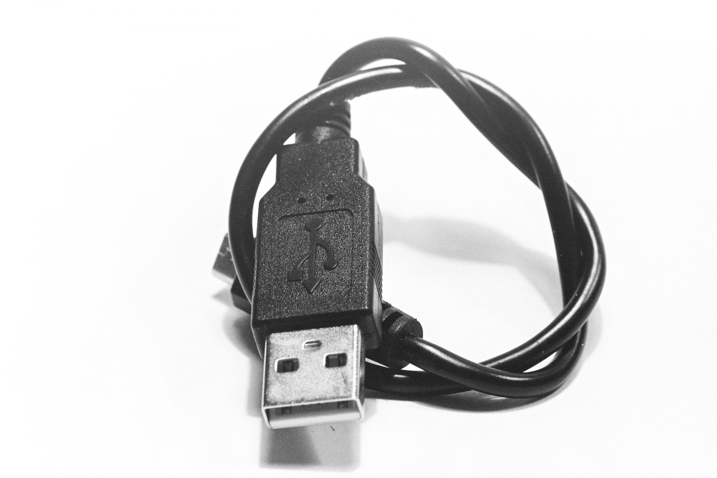 Coiled USB Cable - The coiled USB cable in this image is like a modern-day lifeline, representing the essence of simplicity and minimalism in the world of computing. The sleek black and white design evokes a sense of technological elegance, while the intricate wiring embodies the connectivity and innovation of modern electronic devices.